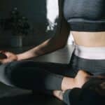 A Woman in Active Wear Meditating in Lotus Position