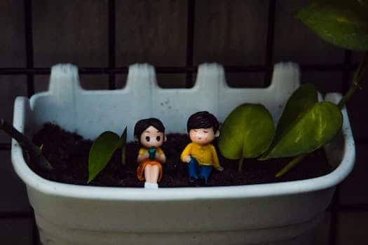 Small figurines in flowerpot with plant