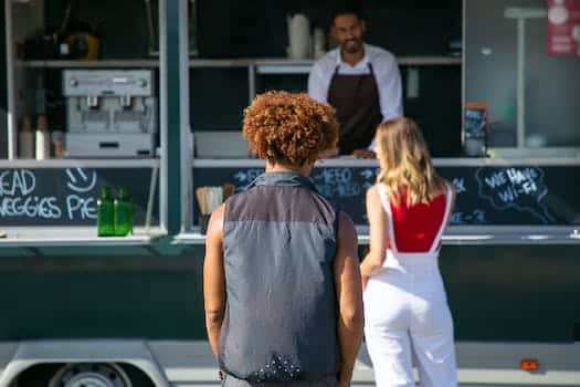 Back view of diverse clients standing near street food truck and choosing lunch