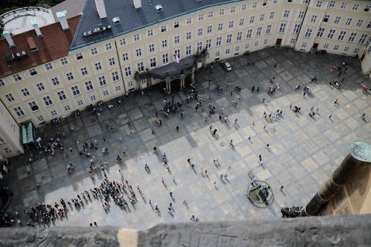 From above of travelers on square in front of aged vintage panoramic exploring sightseeing and studying place in daylight