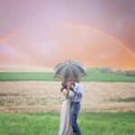 Photo of Couple Holding Umbrella While Kissing