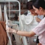 Trendy young Asian women choosing cotton bags in fashion boutique