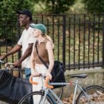 Food Delivery Man and Woman on Bicycles Carrying Food Delivery Bags Talking