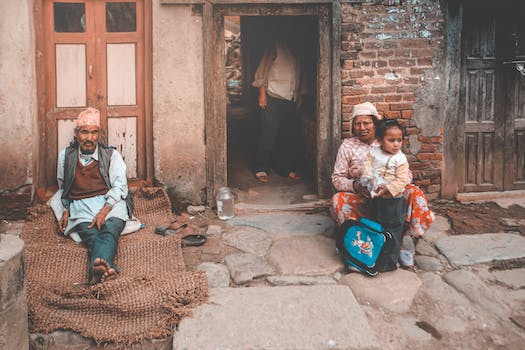 Ethnic people sitting on old street near old house in countryside