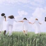 Women in White Dress Running on Green Grass Field