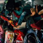 Poor people with many backpacks and bags in old crowded bus having trip during holiday