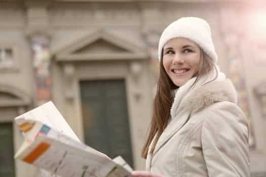 Smiling female tourist with paper map on street