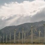 Wind Turbines Near Mountains Under A Cloudy Sky