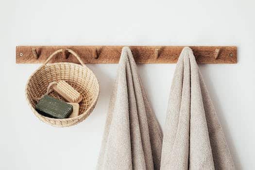Wooden hanger with towels and basket with bathroom products