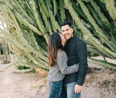 A Couple Standing Beside Big Cactus Plants