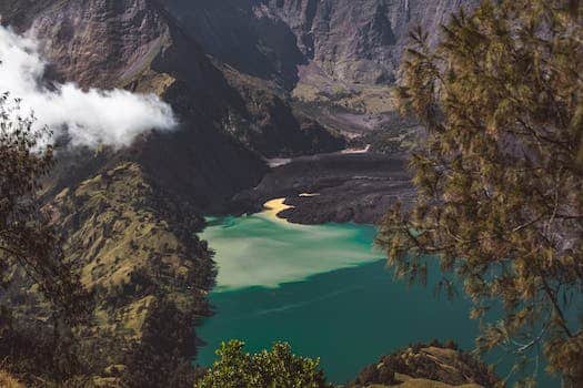 Picturesque turquoise Segara Anak lake located in volcano caldera and surrounded by rocky hills